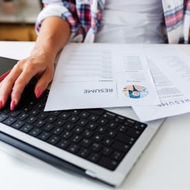 Close up view of Human Resources female hands reading CV of job candidates