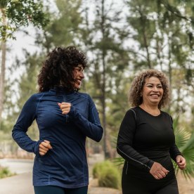 Mother and daughter talking and walking through the public park